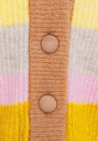 Cardigan tricoté avec des rayures jaunes, roses et beiges, doté d'une finition en fil texturé et doux, et de boutons ronds marron le long de l'avant.