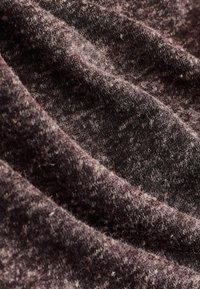 Strukturiertes Gewebe in dunklen Brauntönen mit einem weichen, flauschigen Aussehen, das subtile Farb- und Mustervariationen im gesamten Material aufweist.