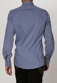 Blauw-witte geruite lange mouwen shirt met een smalle kraag, knoopmanchetten en zijsplitsen aan de onderkant. Gemaakt van lichtgewicht stof.