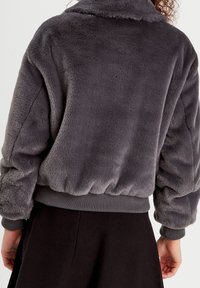 Gray faux fur jacket with a collar, elasticized cuffs and waistband, featuring a soft texture and relaxed fit. No visible fastenings.