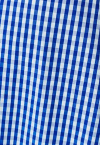 Tessuto a quadri blu e bianchi con un motivo a scacchi, caratterizzato da quadrati uniformi. La trama appare liscia e tessuta.