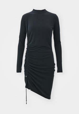 Rochie lungă neagră cu mâneci lungi, fabricată dintr-un material elastic, având un guler tip mock, detalii pliate pe laturi și o linie a tivului asimetrică.