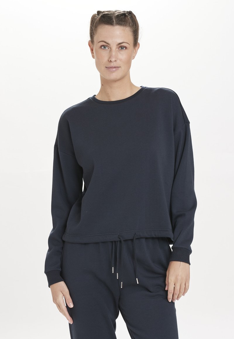 Navyblauw sweatshirt met lange mouwen, ronde hals, ribgebreide manchetten en een trekkoord aan de onderkant. Zacht materiaal met een relaxte pasvorm.