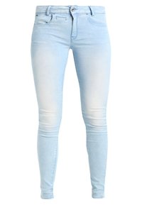Vaqueros ajustados de color azul claro, elaborados en denim, con un patrón desgastado, diseño de cinco bolsillos y cierre de botón.