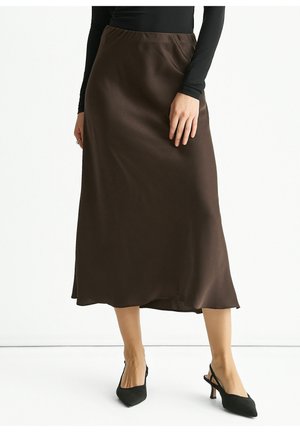 Brown satin midi skirt with a smooth texture, slight sheen, and a relaxed silhouette, paired with pointed black slingback heels.