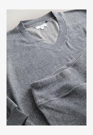 Szary sweter w serek wykonany z miękkiego, teksturowanego materiału. Posiada prążkowany kołnierz i mankiety, z gładkim wykończeniem oraz dopasowanymi detalami szycia.