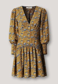 Sukienka w kwiaty w kolorze musztardowym z niebieskimi i białymi wzorami. Posiada dekolt w szpic, bufiaste rękawy oraz marszczoną, warstwową spódnicę. Tkanina o fakturze.