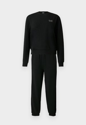 Černá mikina s dlouhým rukávem a odpovídající teplákové kalhoty s malým bílým logem EA7 na levé horní části hrudi.