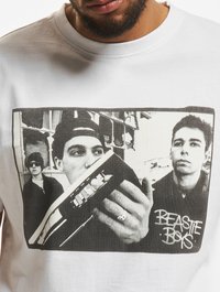 Három férfi fekete-fehérben, az egyik egy boomboxot tart a kezében, a kép jobb oldalán pedig a "BEASTIE BOYS" felirat látható.