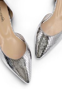 Chaussures à talons hauts argentées avec un bout pointu, présentant un motif texturé semblable à de la peau de serpent et un intérieur lisse de couleur nude.