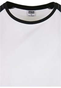 T-shirt blanc avec col rond noir et bordure aux épaules, taille extra petite, étiqueté Urban Classics, fabriqué au Bangladesh.