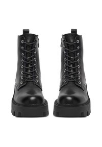 Czarne skórzane botki za kostkę z grubą podeszwą, okrągłym czubkiem i metalowymi oczkami na sznurówki. Wyposażone w pętelkę na pięcie.