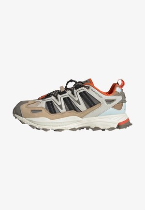 Scarpa da trail running con una combinazione di materiali beige, grigio e nero, caratterizzata da una tomaia testurizzata, suola robusta e un vivace accento arancione.