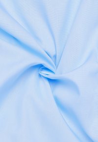 Tessuto azzurro chiaro con una trama liscia, attorcigliato per mostrare la sua caduta. Colore uniforme e fine motivo di intreccio visibili su tutta la superficie.