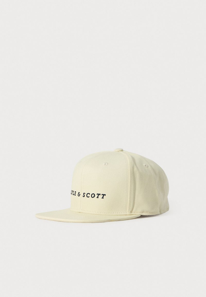 Gorra de béisbol de visera plana en beige con texto bordado en negro "TYLE & SCOTT" en el panel frontal sobre un fondo blanco liso.