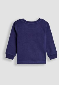 T-paita tummansinisestä pehmeästä puuvillasta, pitkähihaisena. Siinä on pyöreä pääntie, hihansuut käännetty ja sileä pinta, jossa on minimaalinen ompelu.