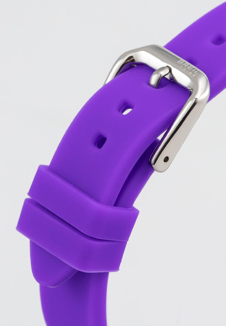 Correa de reloj de silicona púrpura con hebilla metálica plateada. Presenta agujeros ajustables y una textura suave y mate.