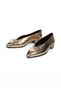 Złote płaskie buty o spiczastym nosku, z perłowym akcentem zabezpieczonym złotym pierścieniem, skórzanym wnętrzem oraz niskim obcasem w kształcie bloku.
