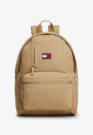 Zaino beige Tommy Jeans con tasca frontale con zip, piccola tasca verticale con zip, spallacci imbottiti e patch con logo sul davanti.
