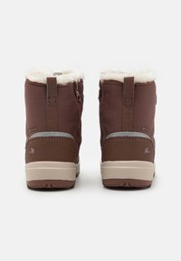 Botas de invierno marrones con parte superior de tejido texturizado, forro de piel sintética en el puño, cremalleras en los laterales y una suela beige en contraste.