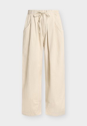 Beige wide-leg pants with elastic waistband, front drawstring, and rounded side pockets, displayed on a plain background.