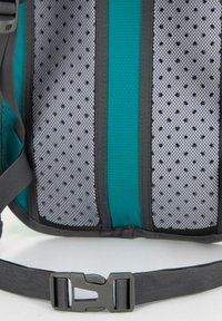 Zaino in rete teal e grigio con texture a pois, spallacci regolabili e chiusura a scatto per una chiusura sicura.