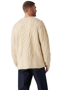Sweter w sploty w kolorze kremowym, z teksturowym wzorem, w oversize'owym kroju i ściągaczami przy mankietach. Miękki materiał o przytulnym wyglądzie.