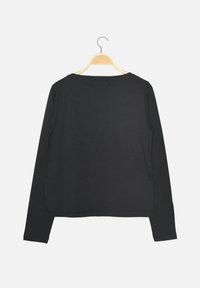 Zwarte lange mouwen shirt hangt aan een houten hanger, met een ronde halslijn en een glad, effen oppervlak zonder patronen.