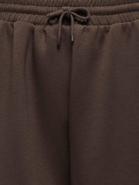 Taille élastique marron avec cordon noué sur un pantalon ou un short en tissu doux.