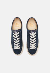 Sneakers de camurça azul-marinho com atacadores brancos e costura em contraste. Logótipo com gráfico de tartaruga na língua, colarinho almofadado e solas de borracha.
