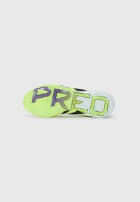 Black soccer cleat sole with a bright yellow-green pattern, featuring the word "PRED" in purple. Clear accents near the edge and textured grip.