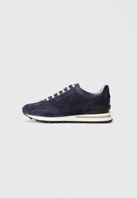 Baskets en suede marine avec lacets blancs et un talon noir contrastant. Présentent une semelle en caoutchouc texturé et un design minimaliste.