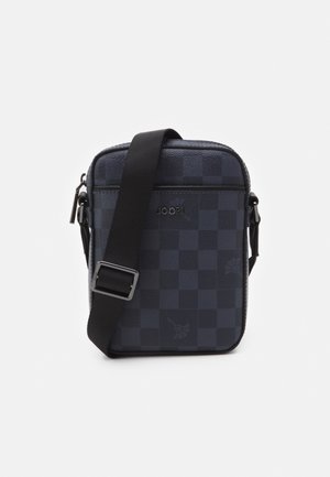 Kleine dunkelblaue und schwarze karierte Umhängetasche mit verstellbarem schwarzem Riemen und silbernem Reißverschluss, mit einem dezenten Schmetterling und "JOOP!"-Logo.