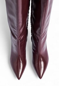 Burgundowe skórzane kozaki za kolano z ostrymi noskami i gładką, elegancką fakturą; dopasowany krój z minimalnymi detalami szycia.