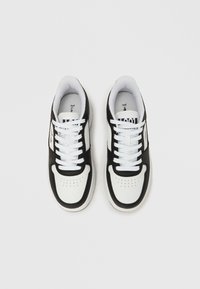 Adidași alb-negru cu partea superioară din piele netedă, vârf rotund, design perforat și șireturi albe pentru o fixare sigură.