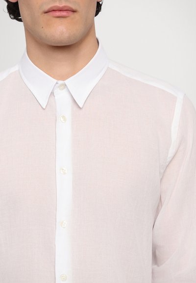 Camisa de lino blanca con cuello abotonado, placket frontal con botones y textura ligera y translúcida.