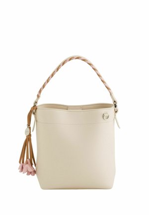 Bolso tipo cubo color crema con asa trenzada y borla marrón adornada con charms rosas en forma de flores.