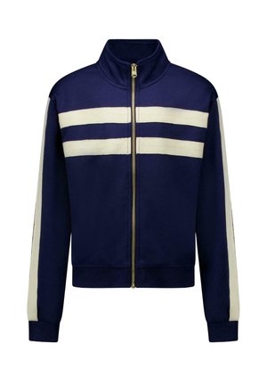 Donkerblauw jack met ritssluiting, twee horizontale witte strepen op de borst en verticale witte strepen langs de mouwen, geribbelde boorden en zoom.