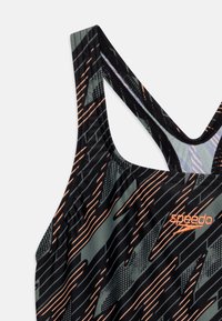 Maillot de bain noir et gris avec un motif abstrait de lignes et de points diagonaux. Présente un design dos nageur et des détails de logo orange contrastants.