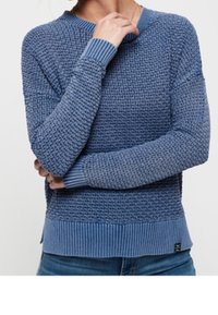 Blue textured knitted sweater with a ribbed hem and cuffs. Features a crew neckline and a loose fit, with varied shades of blue throughout.