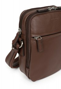 Borsa in pelle marrone con due compartimenti con zip, tracolla regolabile e dettagli in metallo argentato. Texture liscia con cuciture a vista.