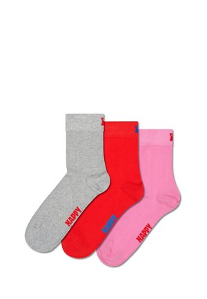 Drei Socken: grau, rot und pink. Jede hat einen gerippten Bund und den Text "HAPPY" in kontrastierenden Farben. Glatte Textur, Material aus Baumwollgemisch.