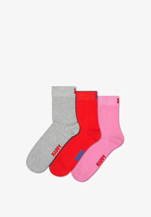 Three socks: grey, red, and pink. Each features a ribbed cuff and "HAPPY" text in contrasting colors. Smooth texture, cotton blend material.