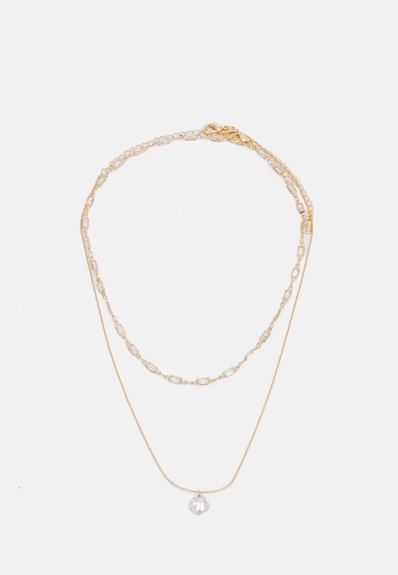 Collier superposé doré comprenant une chaîne délicate et un pendentif sphérique clair. Comprend des accents de maillons rectangulaires pour plus de détail.