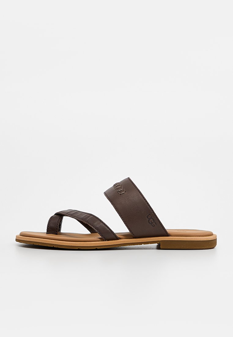 Chanclas de cuero marrón con dos tiras cruzadas, suela de goma plana y logotipos en relieve en las tiras. Textura suave y diseño minimalista.