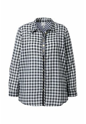 Camisa a cuadros en blanco y negro con mangas largas, botonadura frontal y cuello de patrón contrastante. Presenta botones en tono dorado. Corte regular.