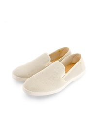 Baskets slip-on blanches en maille avec une surface texturée, un bout rond et des ouvertures élastiques. Semelle en caoutchouc avec un minimum de détails.