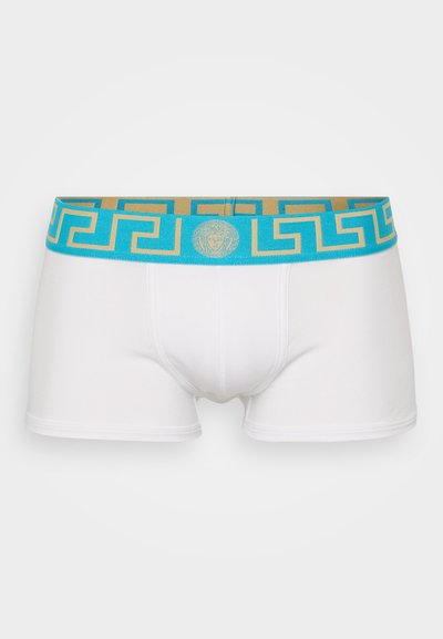 Boxeri albi confecționați dintr-un material elastic, cu un tiv de talie în nuanțe de turcoaz și auriu, decorat cu un design negru de cheie grecească și un logo circular în mijloc.