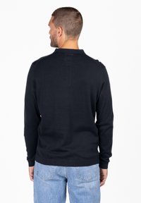 Dunkelblauer Pullover mit langen Ärmeln, gerippten Bündchen und Saum. Glatte Textur, schlichtes Design, Rückansicht festgehalten.