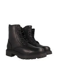 Botas de cuero negro hasta el tobillo con punta redonda, diseño con cordones, cremallera lateral y suela de goma resistente con un patrón de relieve pronunciado.